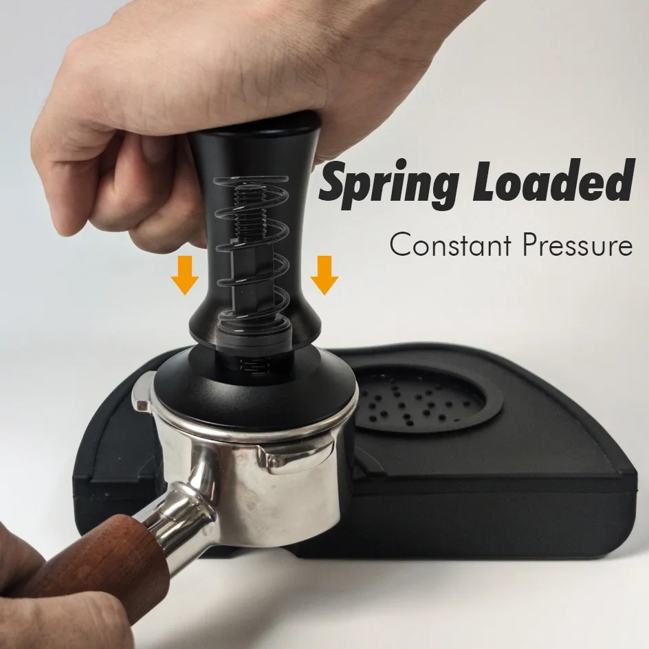 Spring-loaded coffee tamper being pressed into a portafilter, the spring visibly compressed under the handle